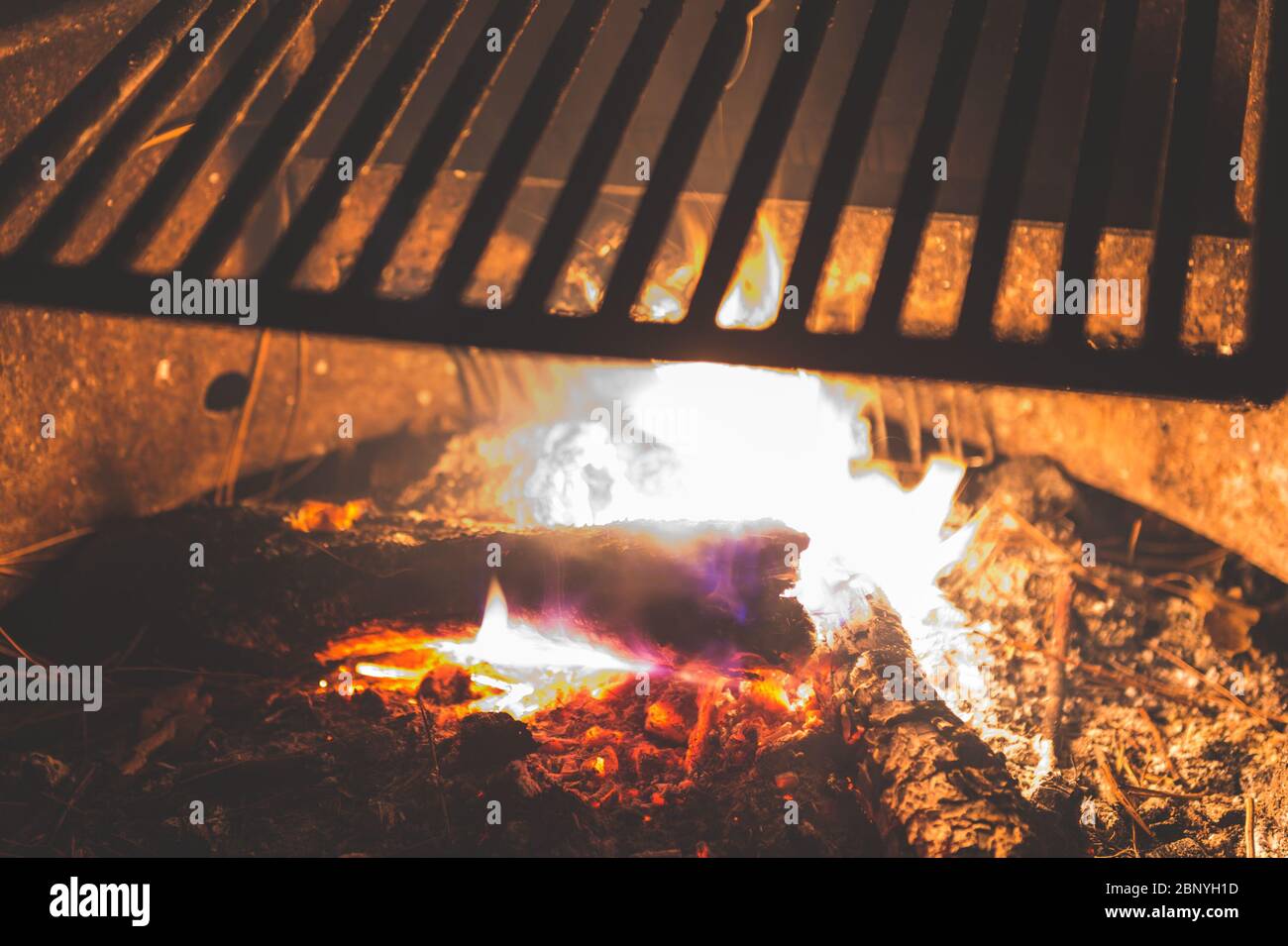 Stainless Steel BBQ Grill over bonfire im camp site in campground at night. Stock Photo