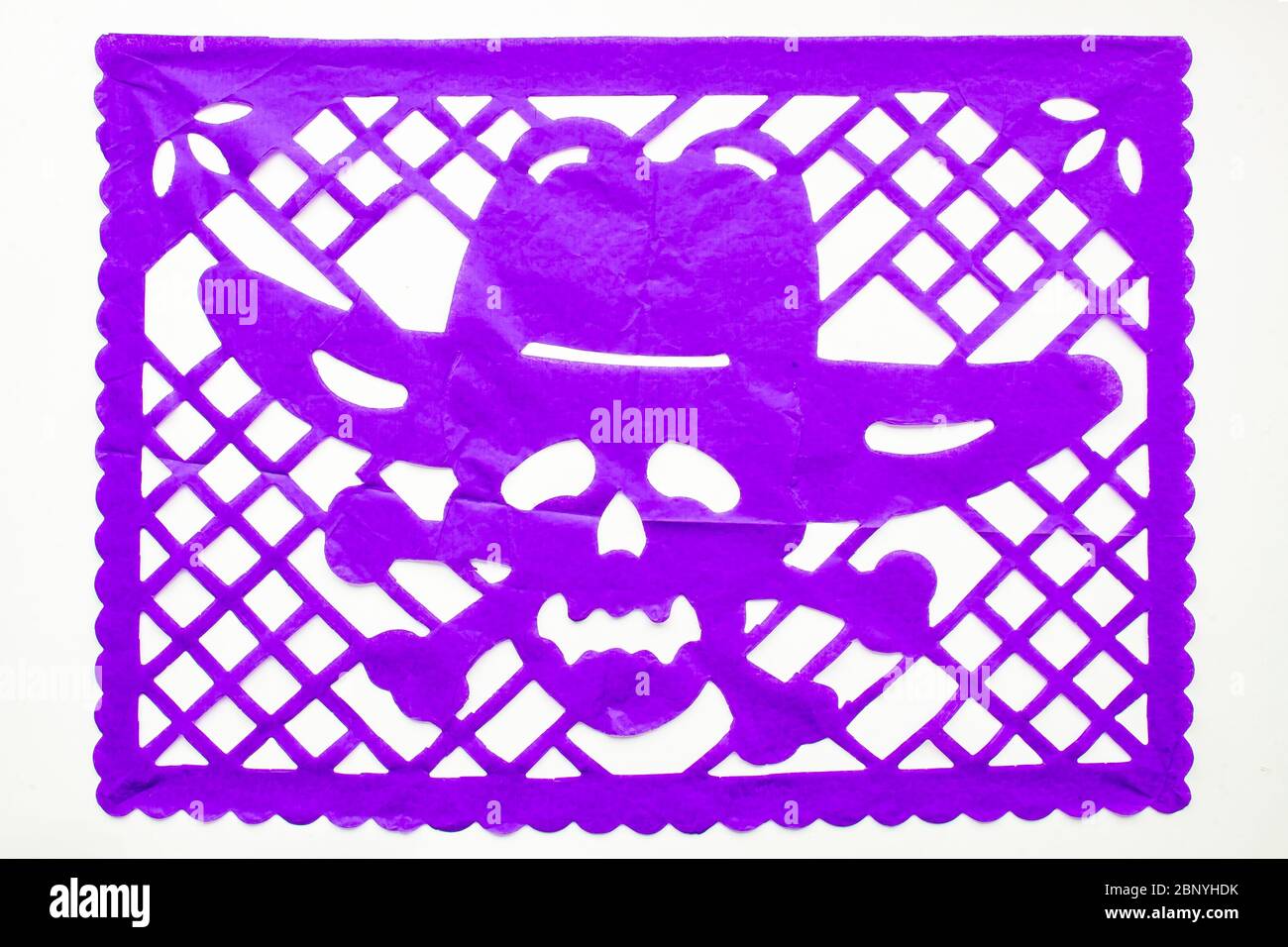 Day of the Dead, Papel Picado. Purple Real traditional Mexican paper cutting flag. Isolated on white background. Stock Photo