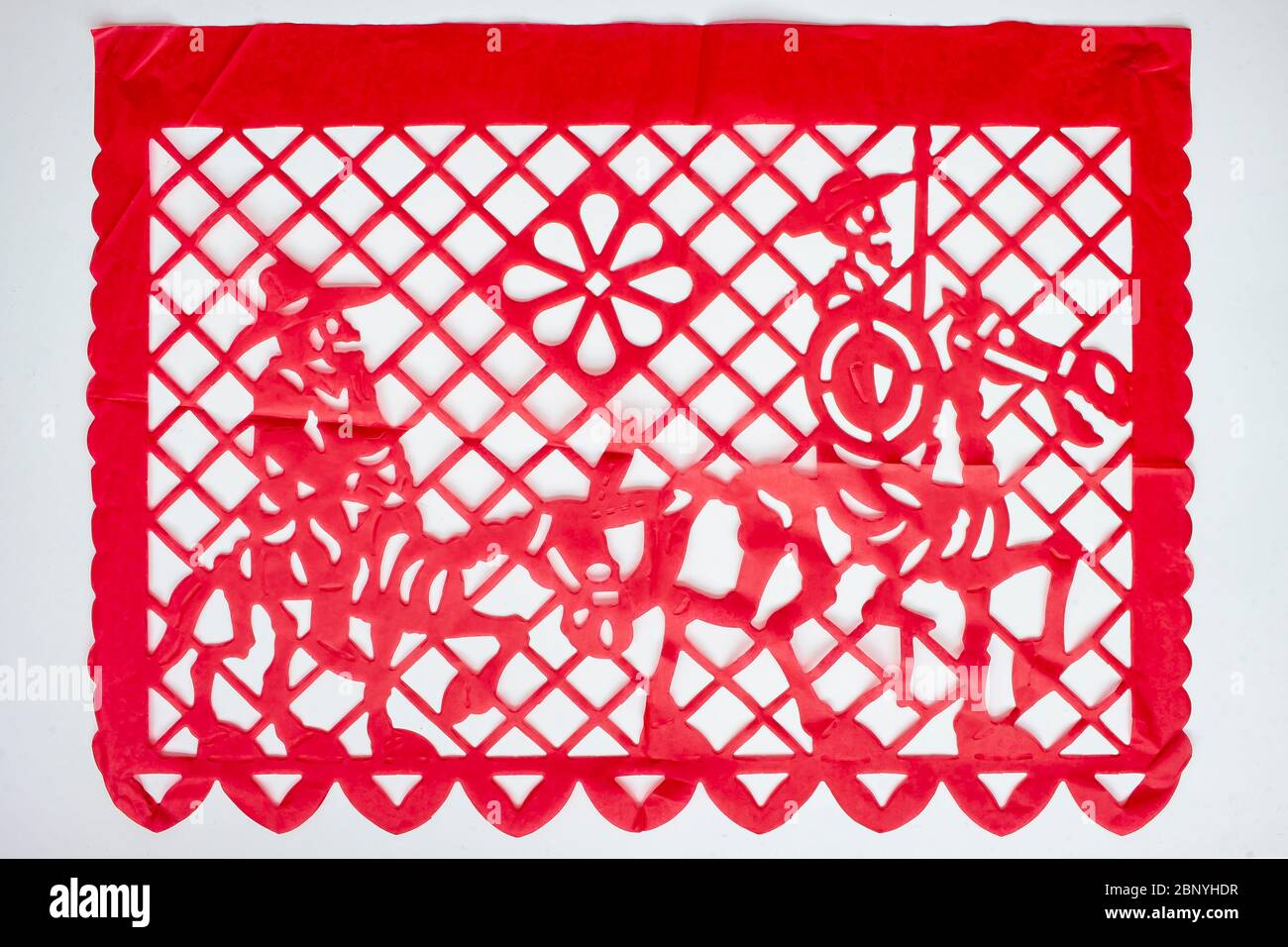 Day of the Dead, Papel Picado. Red Real traditional Mexican paper cutting flag. Isolated on white background. Stock Photo