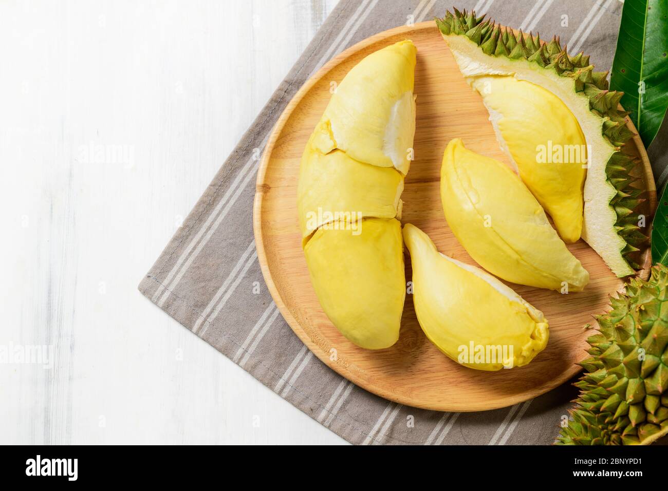 Top view of Fresh durian (monthong) on wood dish and white wood background, king of fruit from
