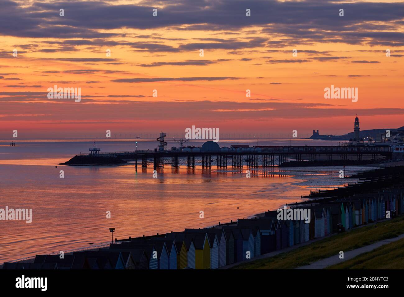 Herne Bay, Kent, UK. 17th May 2020: UK Weather. Dawn just before sunrise at Herne Bay with the pier, clocktower and on the horizon Reculver Towers silhouetted by the early morning glow. Fine warm weather is forecast for the week ahead as people take more advantage of the  reduced lockdown rules, but  they are still asked to think twice about travel to the seaside or beauty spots. Credit: Alan Payton/Alamy Live News Stock Photo