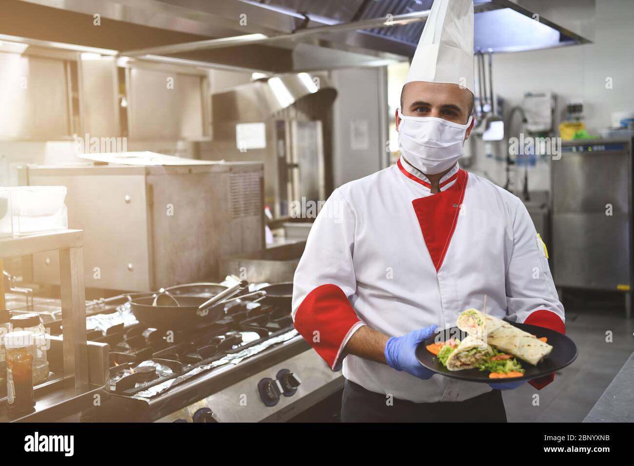 chef cook wearing face protective medical mask for protection from corona  virus disease with plate of authentic sandwich at professional restaurant  ki Stock Photo - Alamy