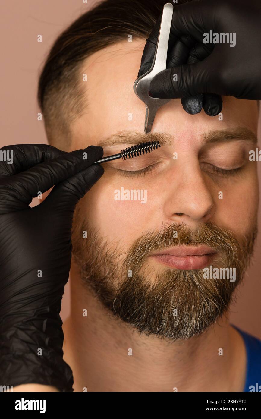 Professional barber doing threading procedure and correcting shape of