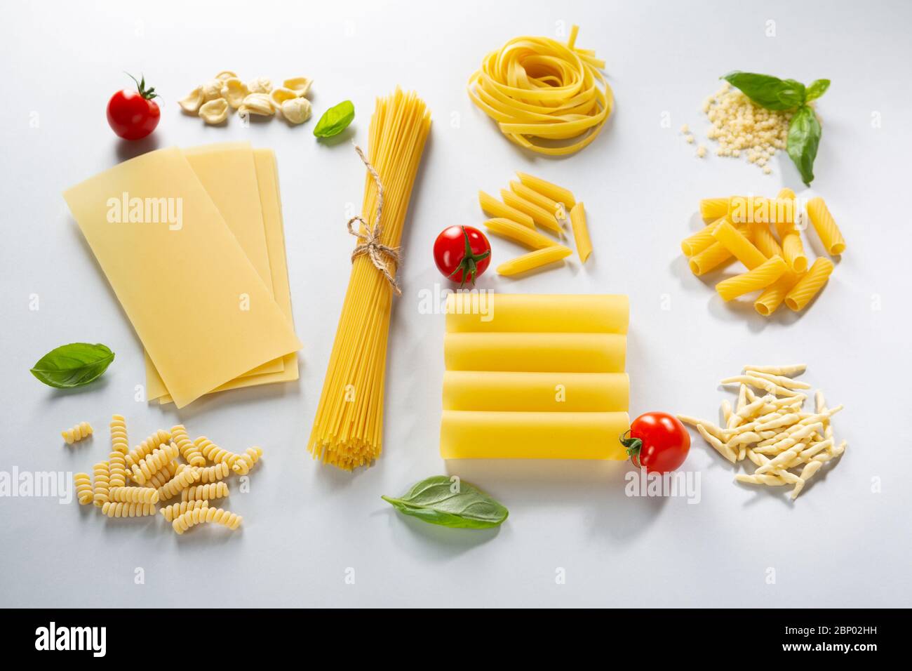 Various pasta and basil with cherry tomatoes Stock Photo