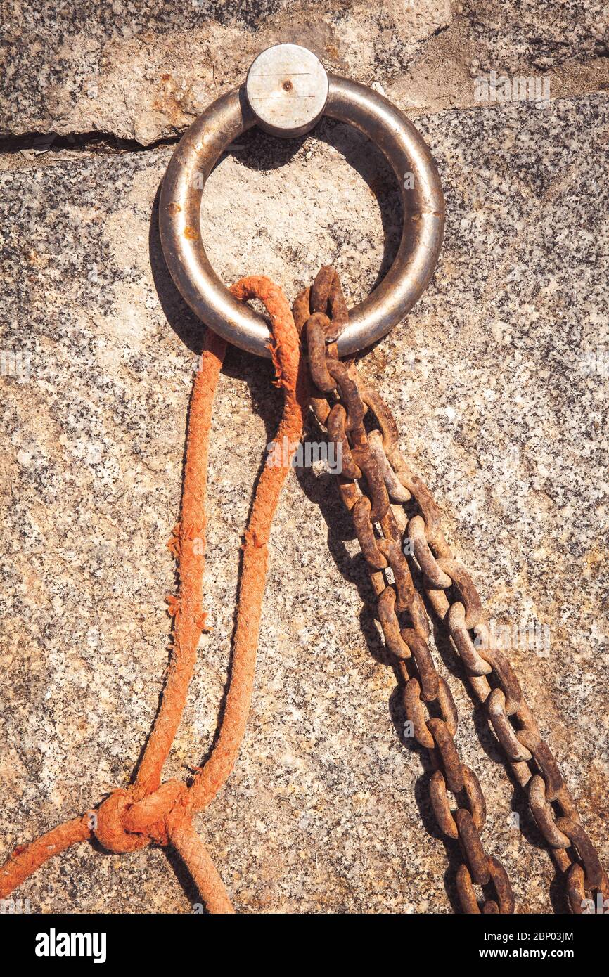 Steel ring and mooring lines in a seaport. Rusty iron chain and orange hemp rope Stock Photo Alamy