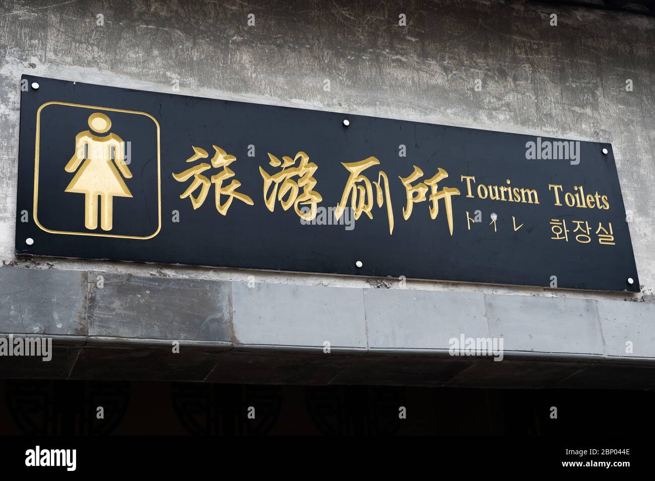 Chinese signage with a humorous translation marks the restrooms in Hongcun, China. Stock Photo