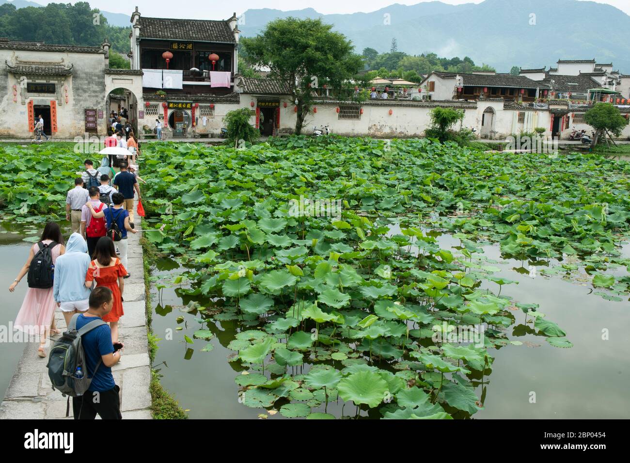 A stone footbridge crosses over Moon Pond, leading tourists into Hongcun village in Huangshan City. Stock Photo