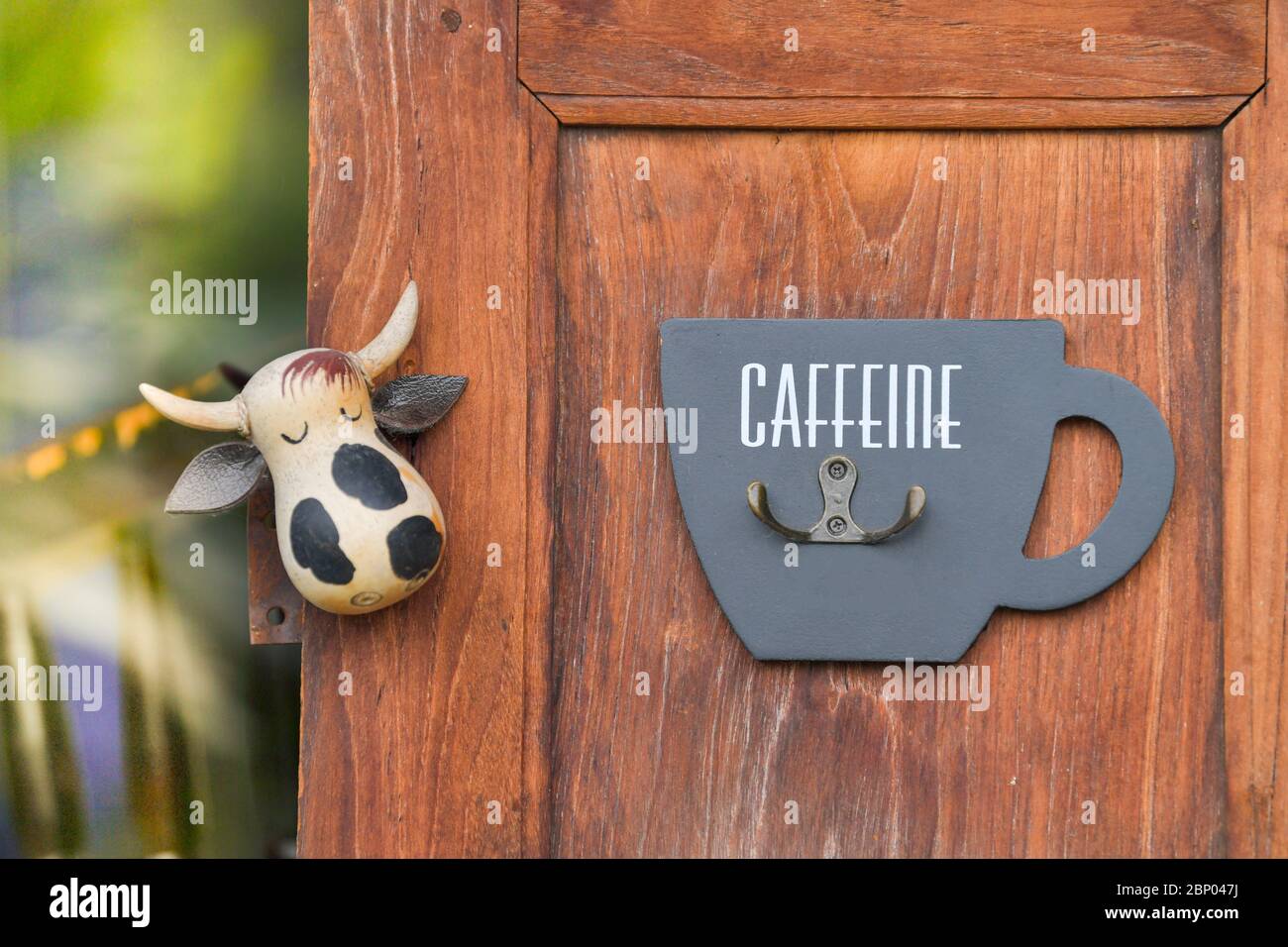 Bottle opener and cow doll on a wooden wall Stock Photo