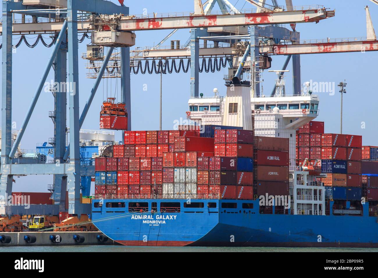 Large Container Ship Docked At A Commercial Port During Loading And