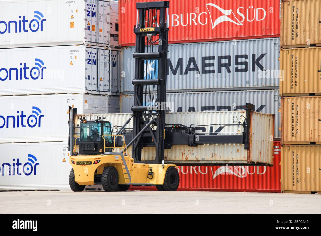 Hyster Container handler lifting a Shipping container in a local port. Stock Photo