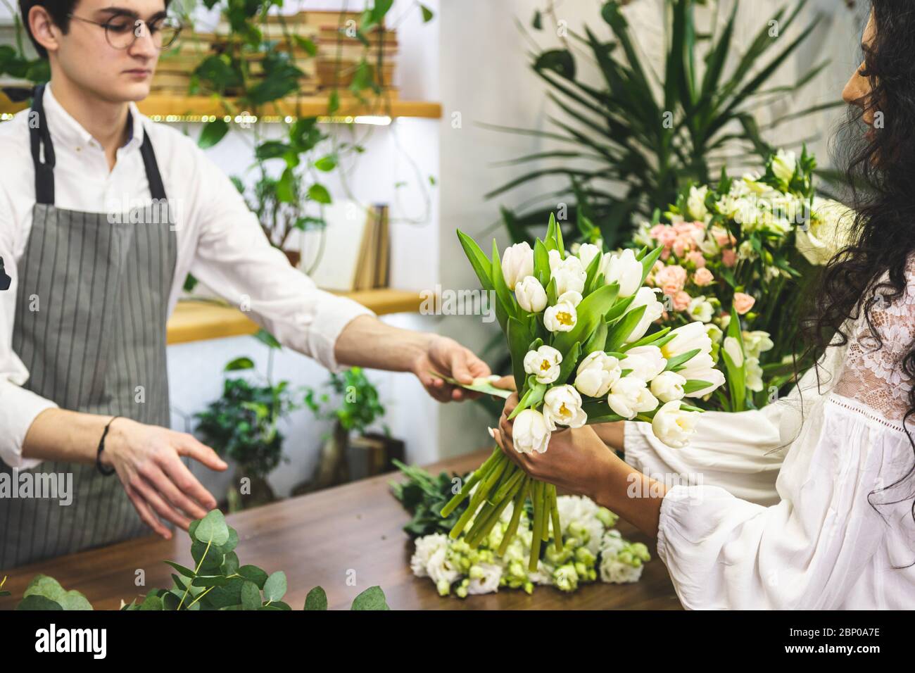 Shopping at the store. Attractive male seller sells a bouquet of