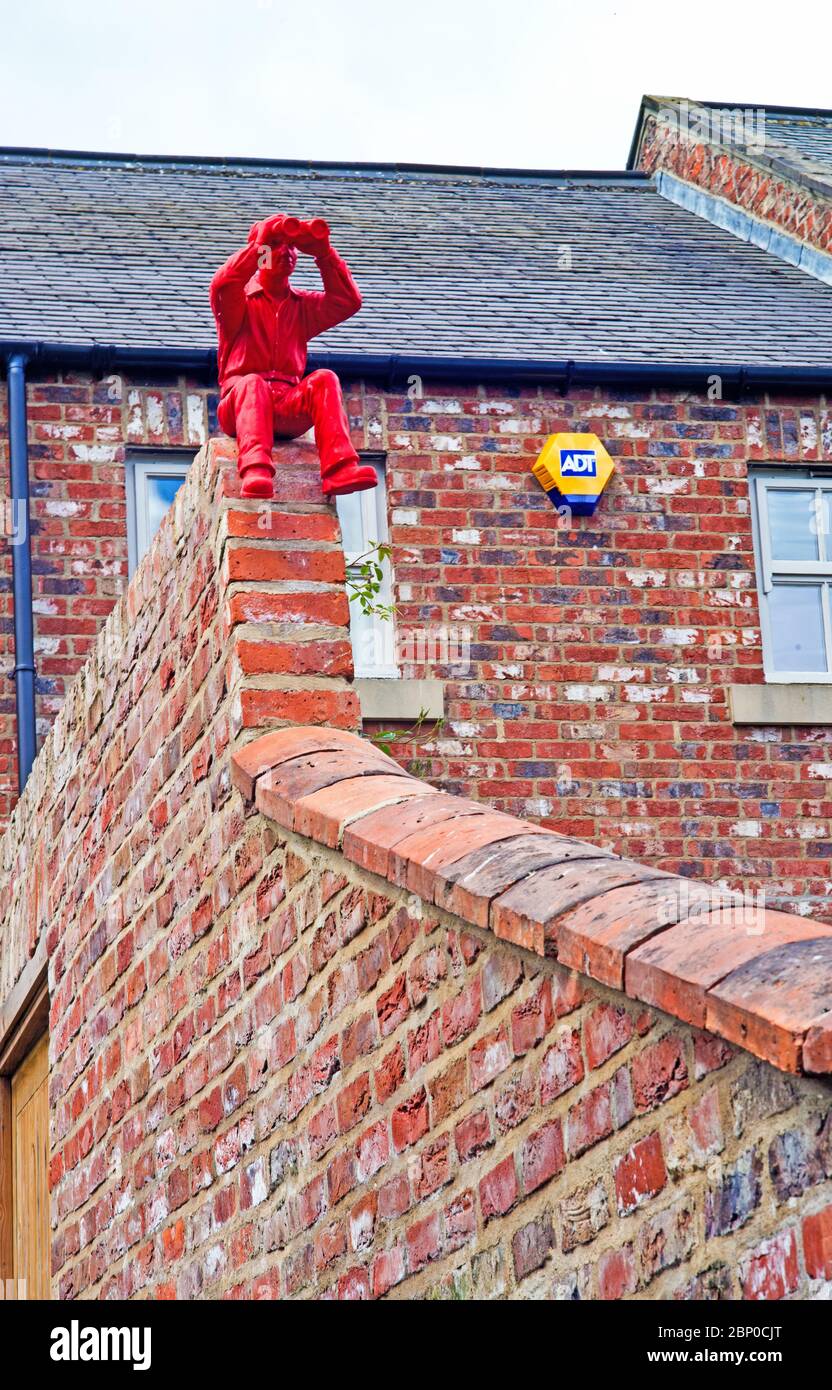 Red man with Binoculars on garden Wall, Hurworth on Tees, Borough of Darlington, England Stock Photo