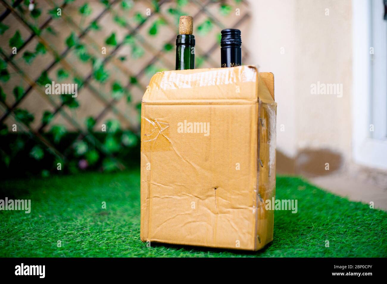 Alcohol in a cardboard box with beer and wine home delivered through online app shot in a garden at home Stock Photo