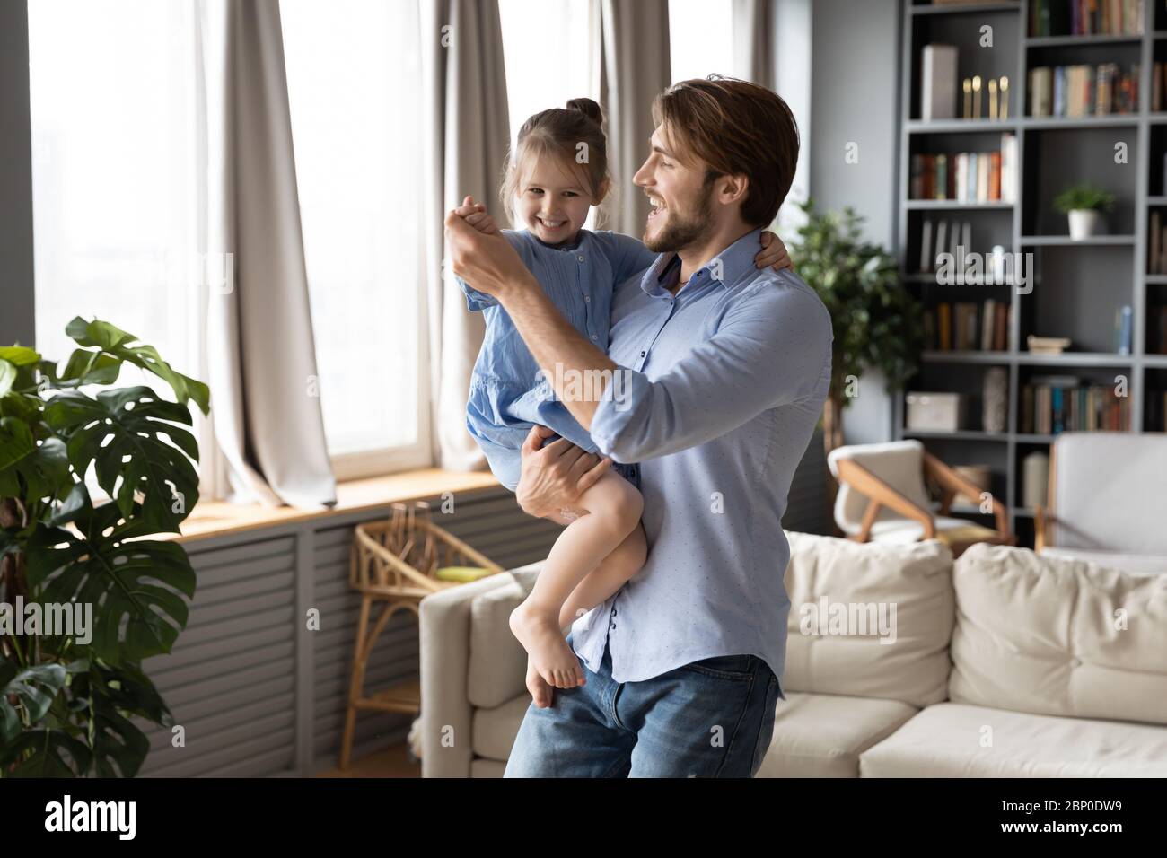Happy young dad dancing with cute little daughter Stock Photo