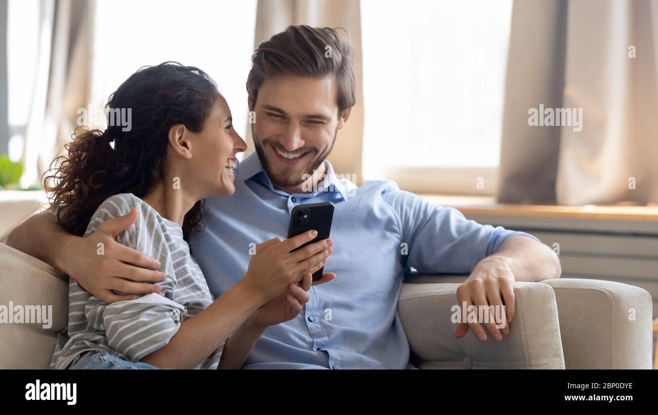 Happy young couple using modern smartphone together Stock Photo