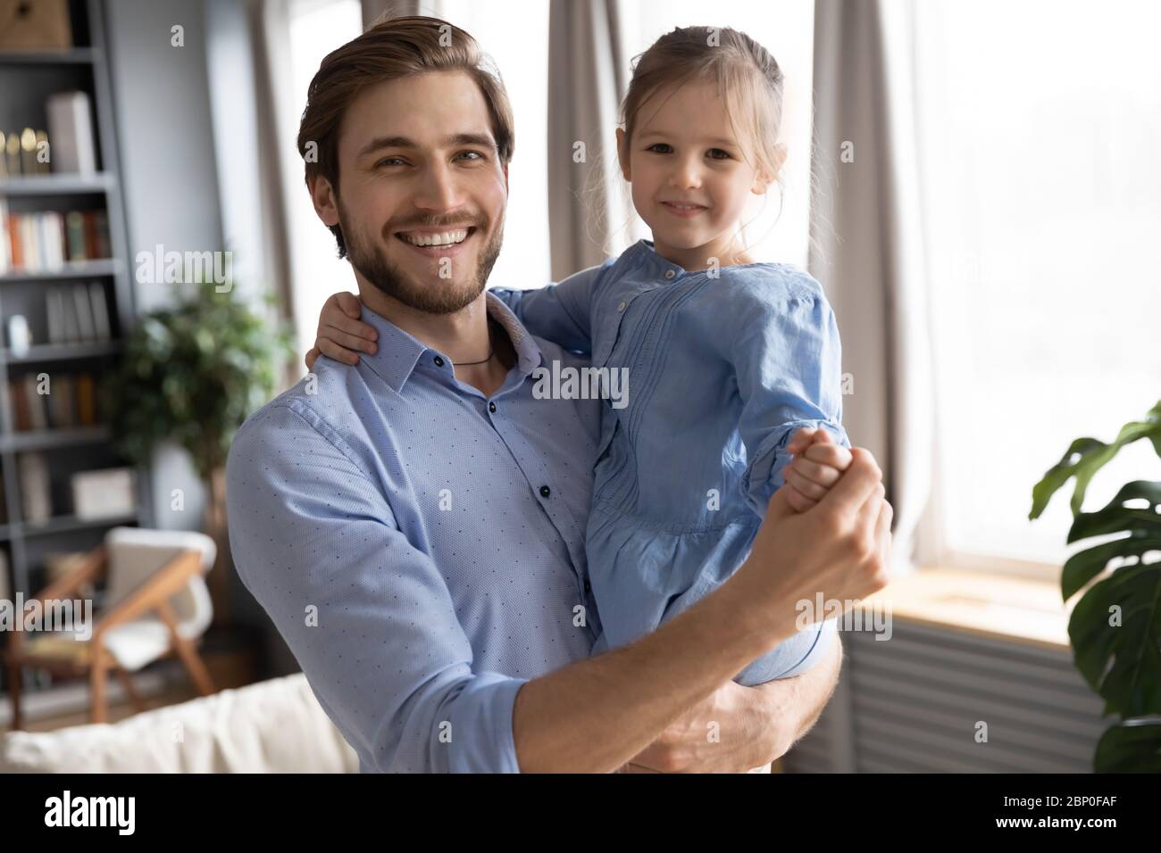 Portrait of happy dad dancing with little daughter Stock Photo