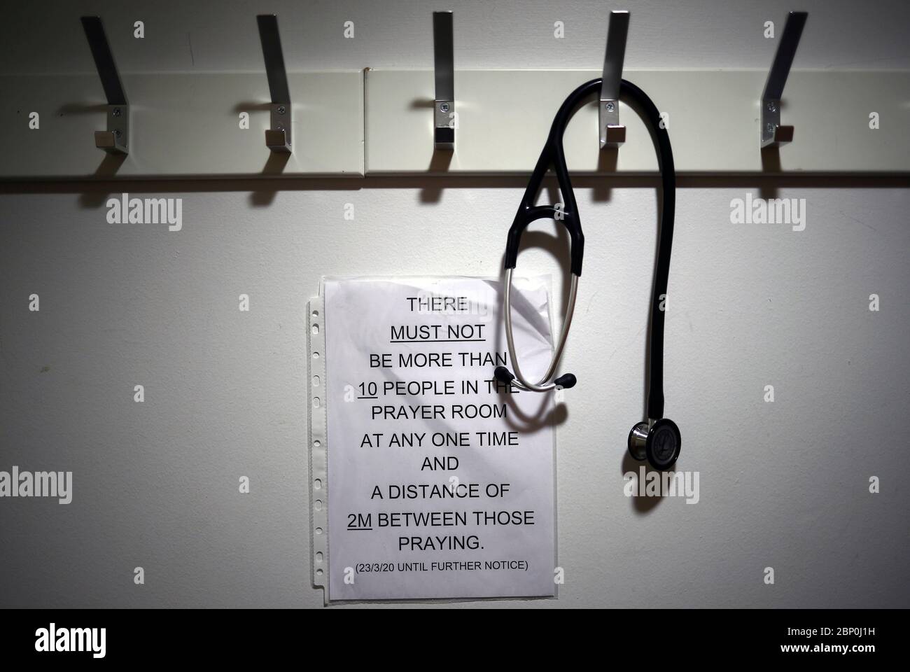 A stethoscope hangs on a coat hook at the entrance to the Muslim prayer room at The Royal Blackburn Teaching Hospital in East Lancashire during the outbreak of the coronavirus disease. Stock Photo