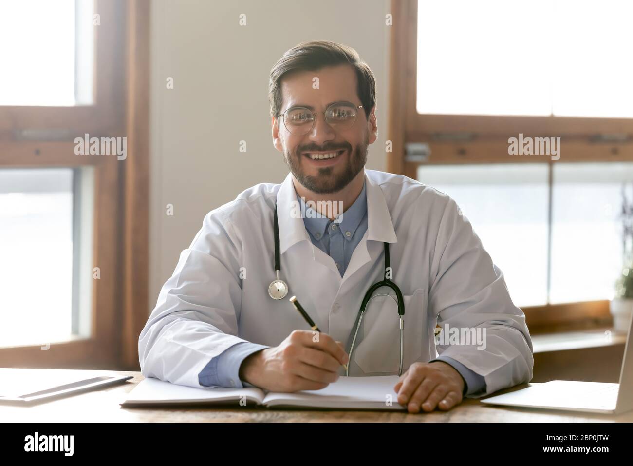 Portrait of smiling male doctor posing at workplace Stock Photo - Alamy