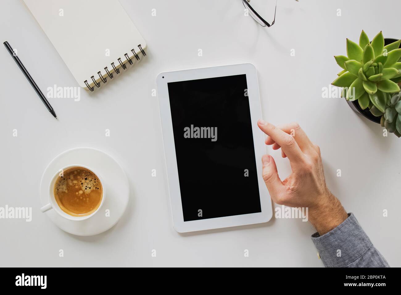 Man working on and drinking coffee at his workplace. Stock Photo