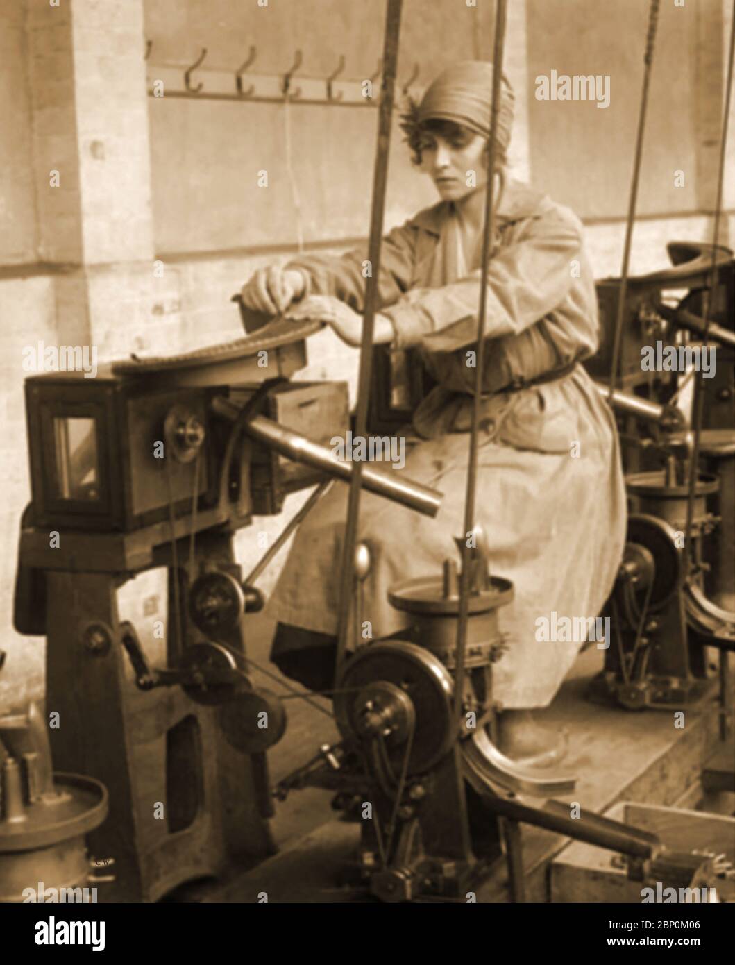WWI - MUNITIONS FACILITIES IN THE UK. - A women (known as a Munitioneer) at work during WW1 operating a cartridge machine Stock Photo