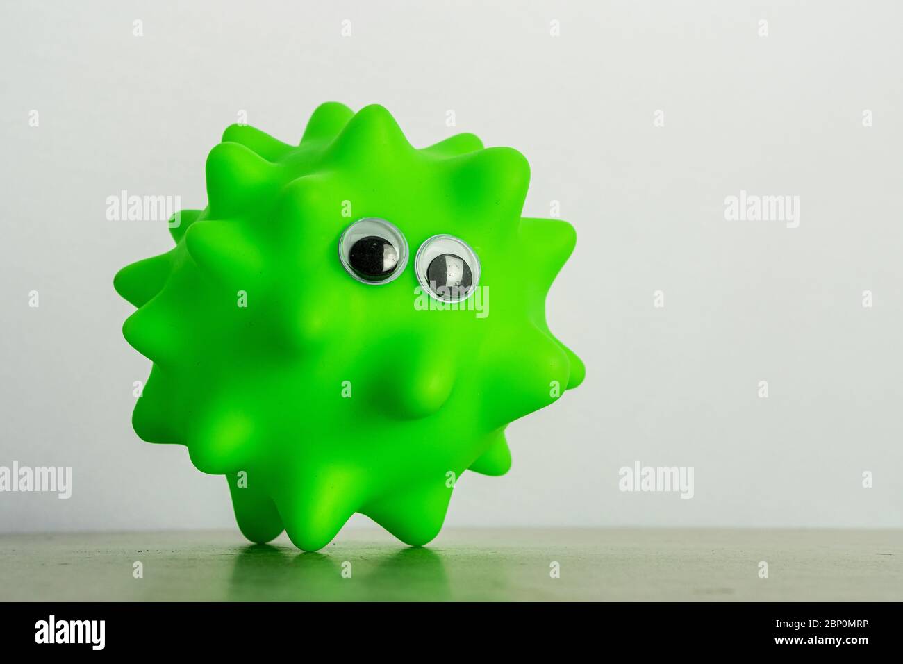 A green dog toy with eyes as a symbol of a virus o bacteria Stock Photo Alamy