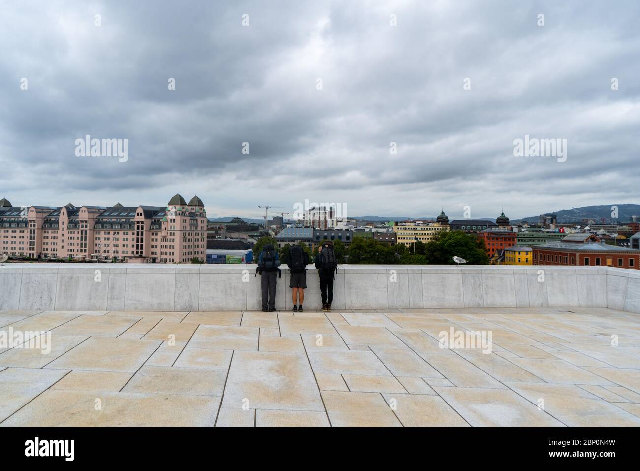 Three travellers enjoying the beautiful view from Norwegian National Opera and Ballet building in Oslo. August 2019 Stock Photo