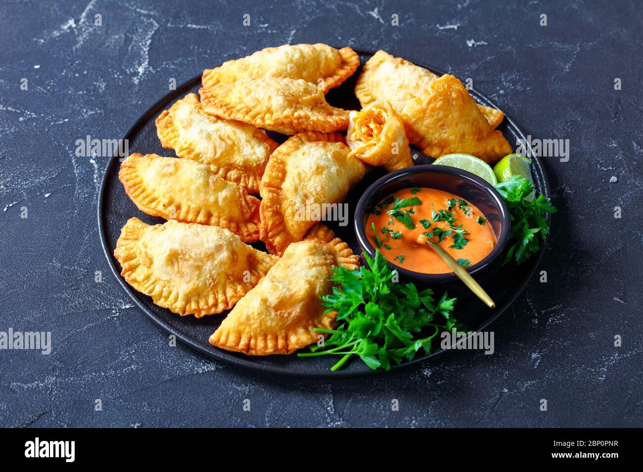 deepfried Buffalo Chicken Empanadas with LowCalorie Dip on a black