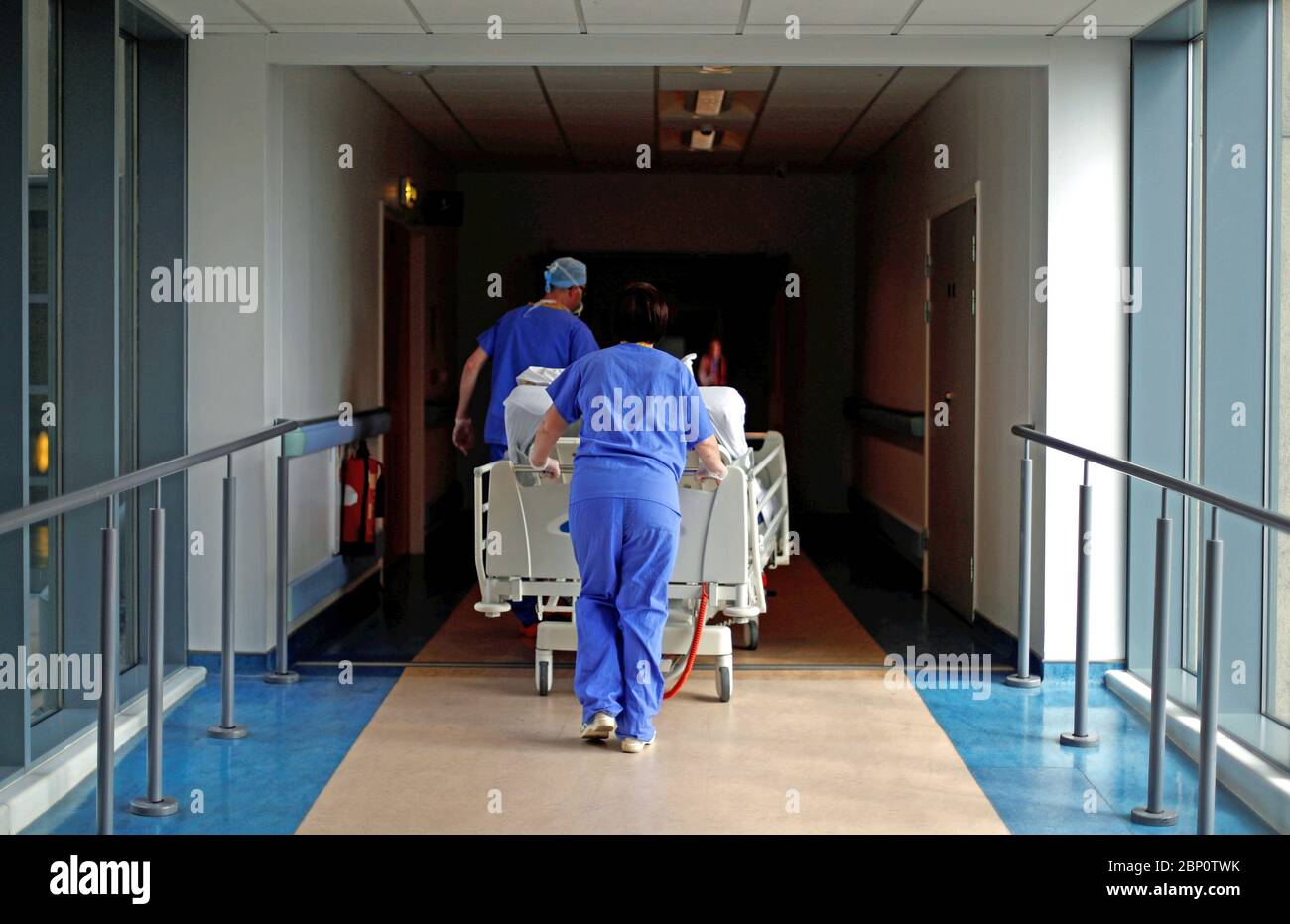 Medical staff transfer a patient through a corridor at The Royal Blackburn Teaching Hospital in East Lancashire during the outbreak of the coronavirus disease. Stock Photo
