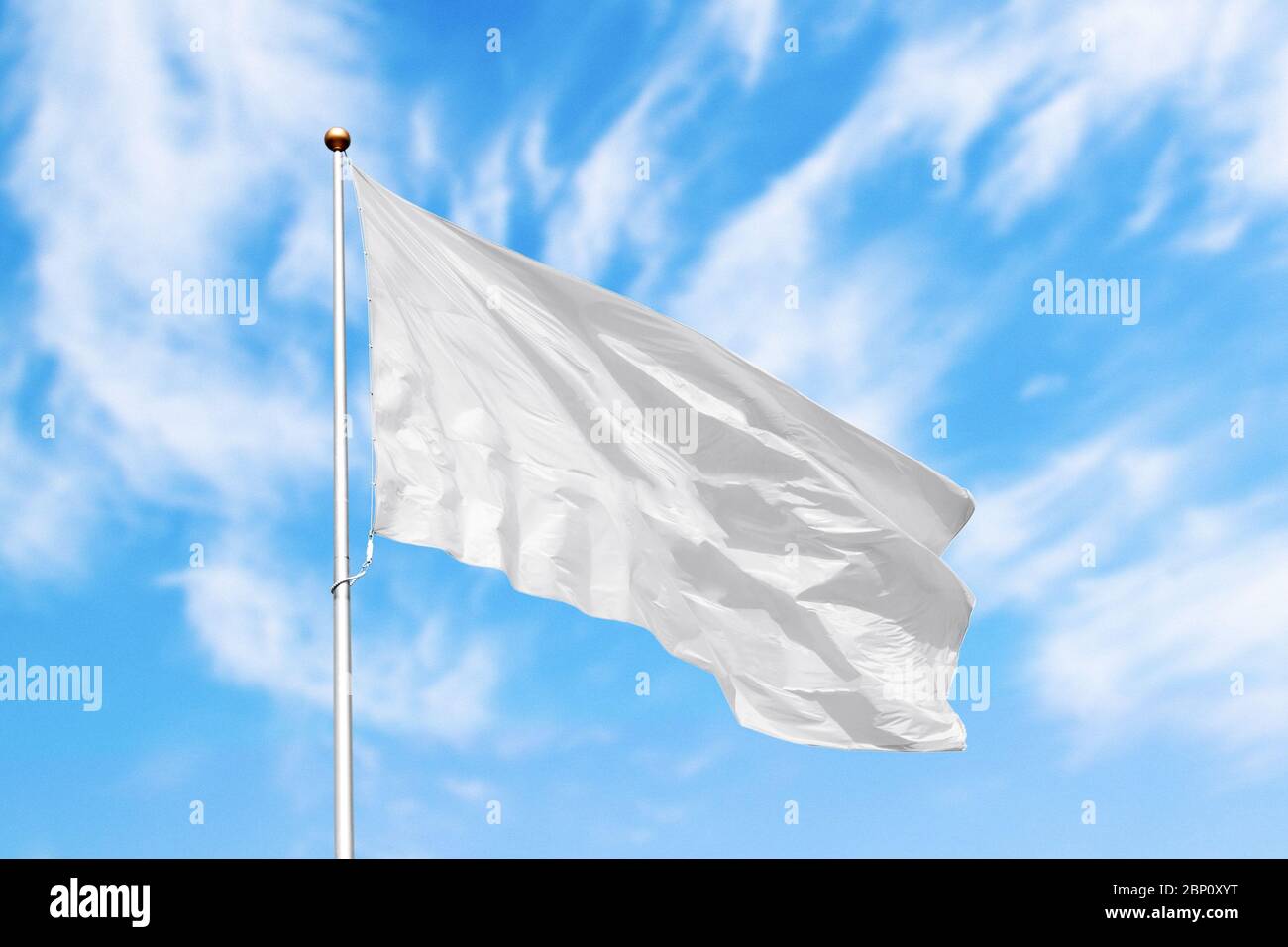 Blank white flag on pole waving in the wind in the background of cloudy sky. Colorful outdoor picture with empty flag mockup Stock Photo