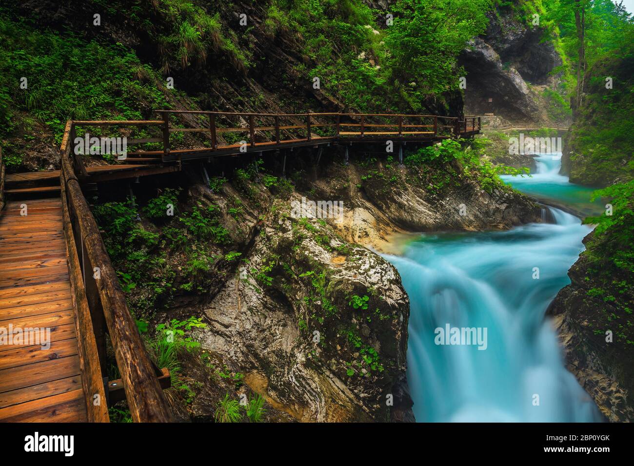 Famous nature touristic attraction near Bled. Majestic Vintgar gorge with wooden footbridge and noisy emerald color Radovna river, near Bled, Gorje, S Stock Photo