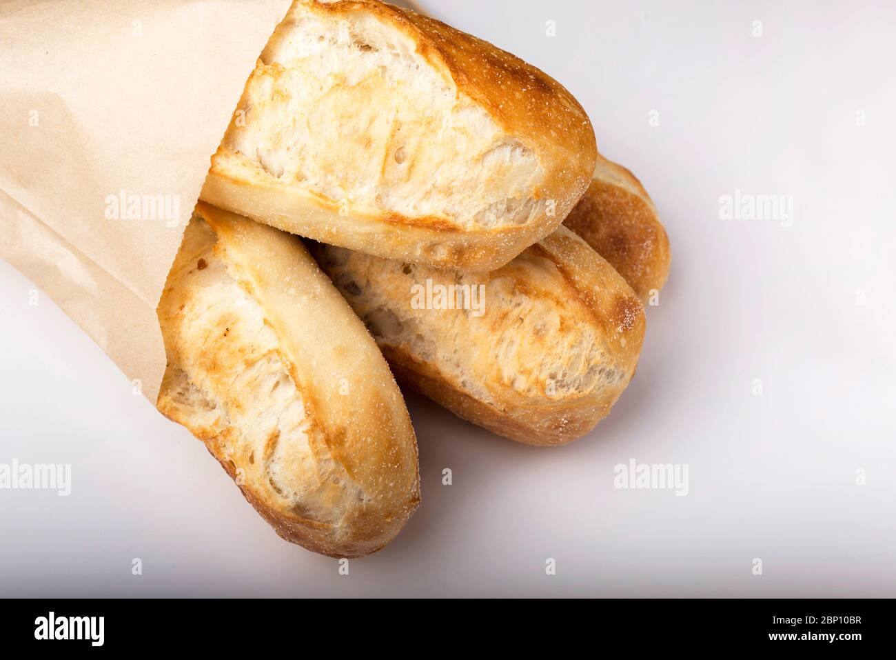 French baguettes in paper bag isolated on light background Stock Photo ...