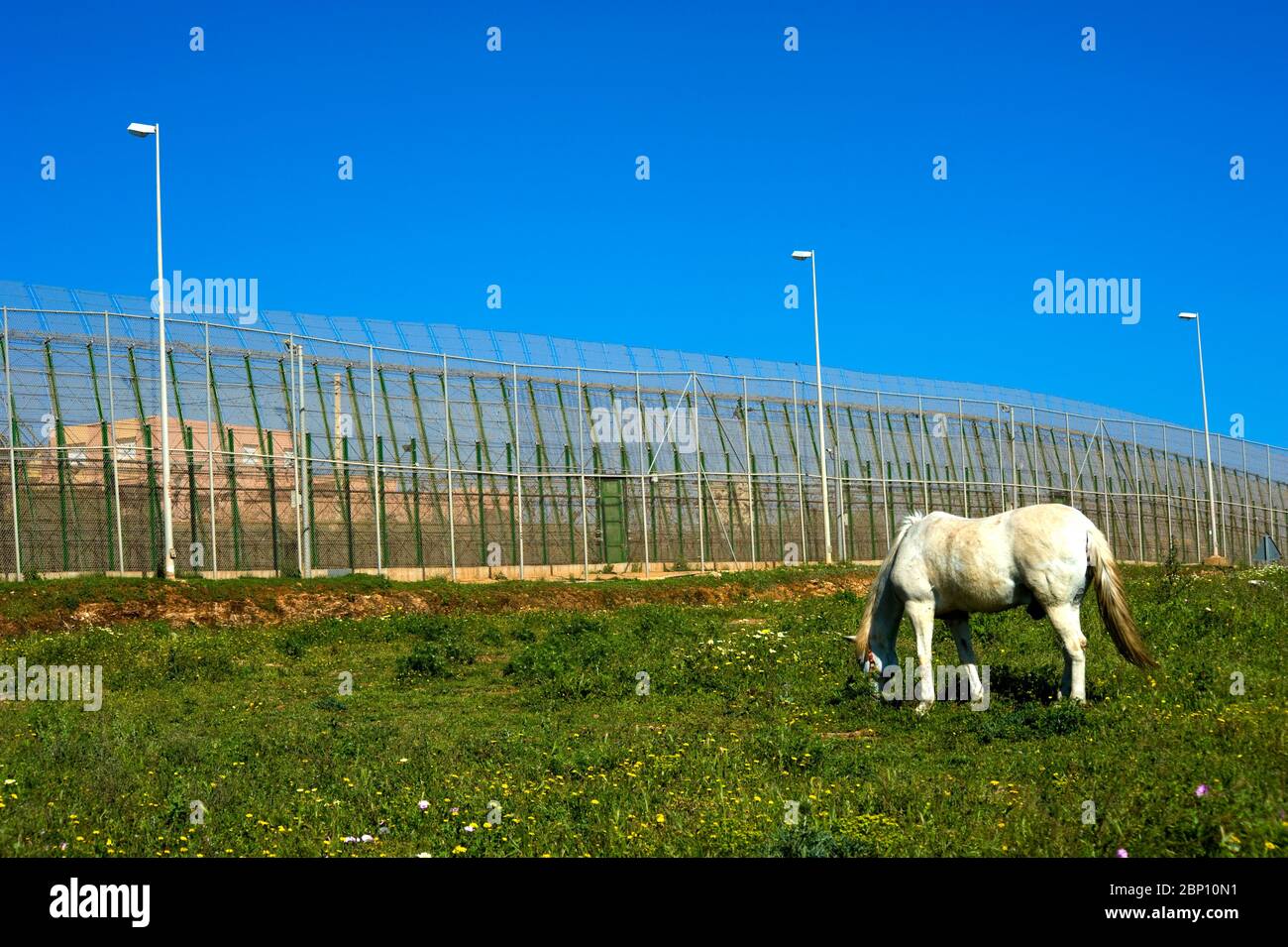 MELILLA,SPAIN-APRIL 19 : Perimeter fence that separates the Spanish enclave of Melilla and Morocco on April 19,2010 in Melilla, Spain. The fence which marks the border around the Spanish enclave in northern Morocco was build to discourage illegal immigrants from attempting to enter to Melilla.  ( Photo by Jordi Cami) Stock Photo