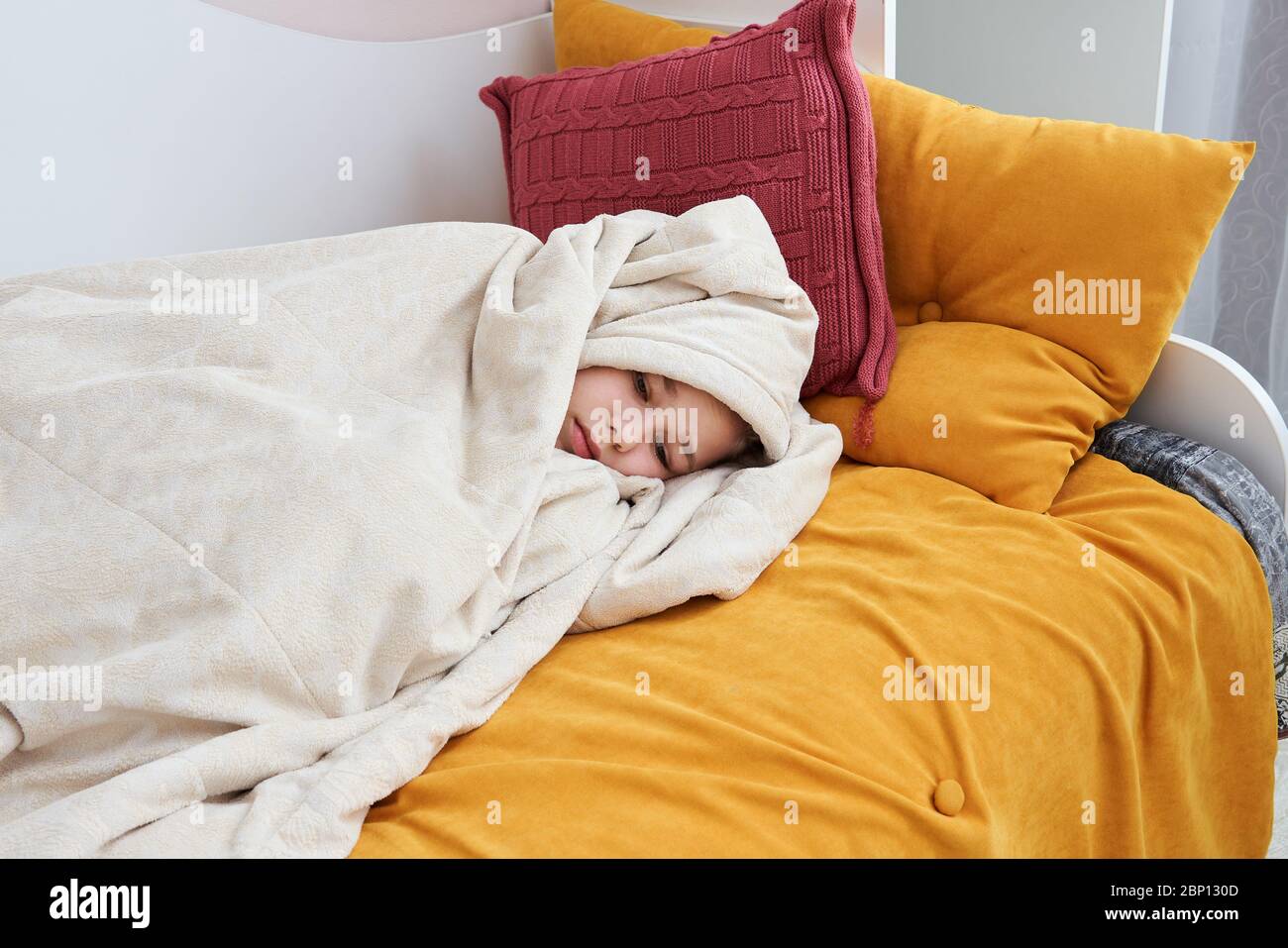 Cute sad girl in bed wrapped in soft blanket Stock Photo Alamy