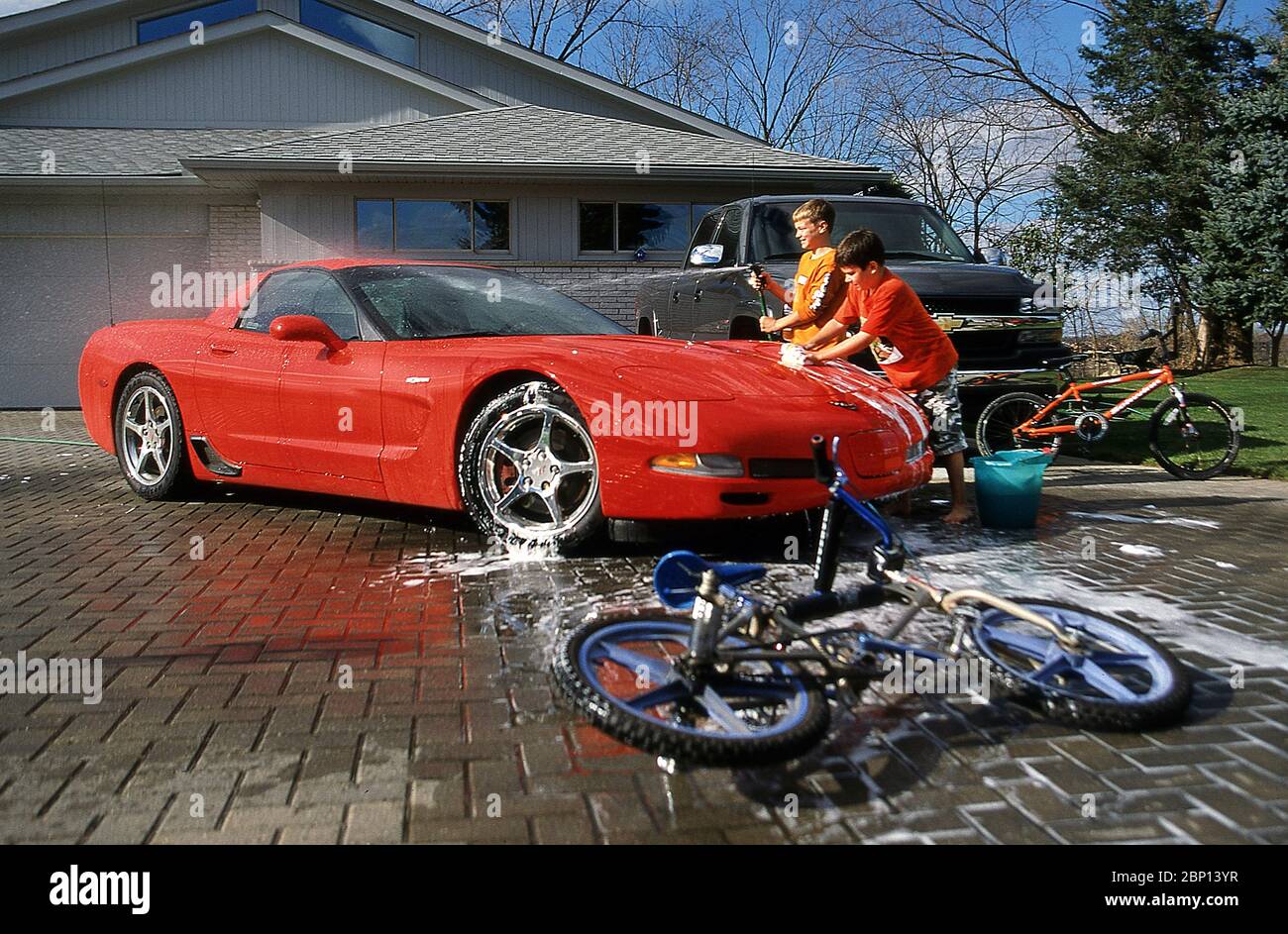 Two boy's washing a classic Chevrolet Corvette. Stock Photo