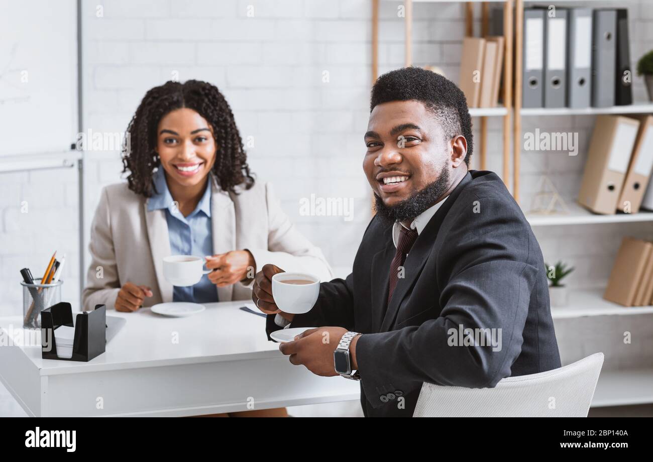 Smiling personnel manager and successful vacancy candidate drinking