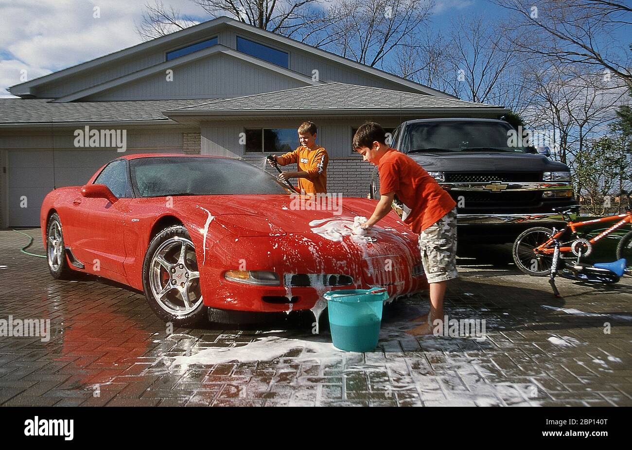 Two boy's washing a classic Chevrolet Corvette. Stock Photo
