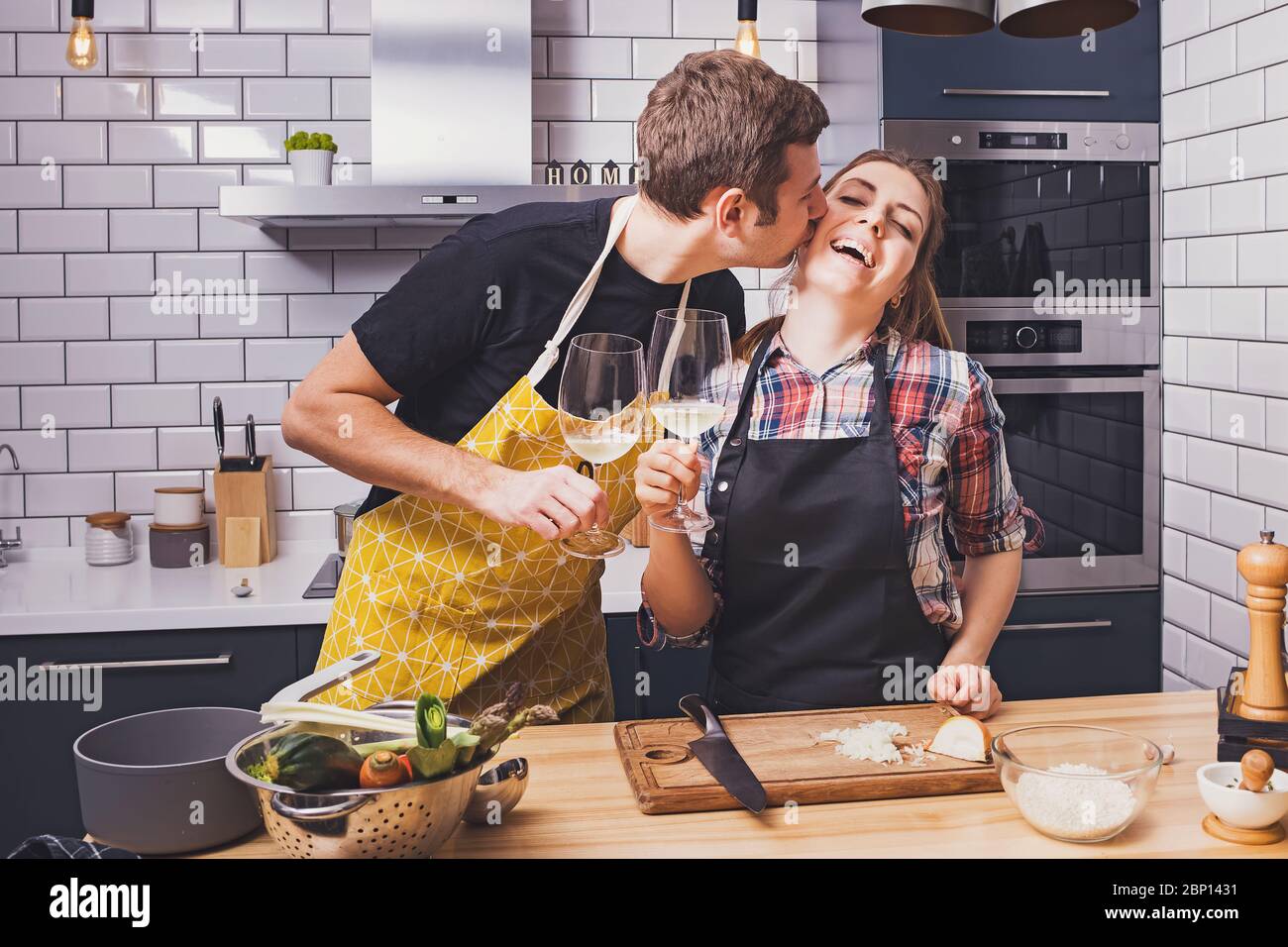 Young cheerful couple preparing food together Stock Photo