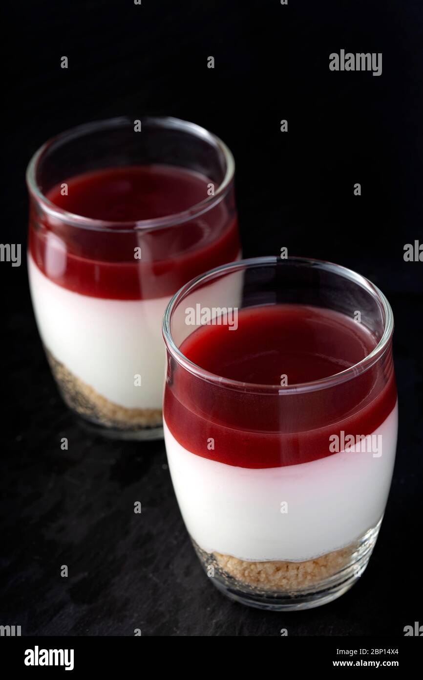 Sweet raspberry dessert in glass over dark slate Stock Photo