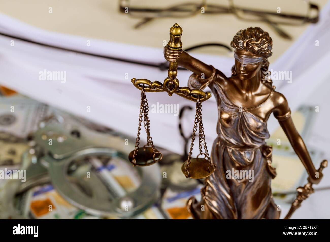 Figure Justice holding the scales of justice with lawyer working on documents Stock Photo