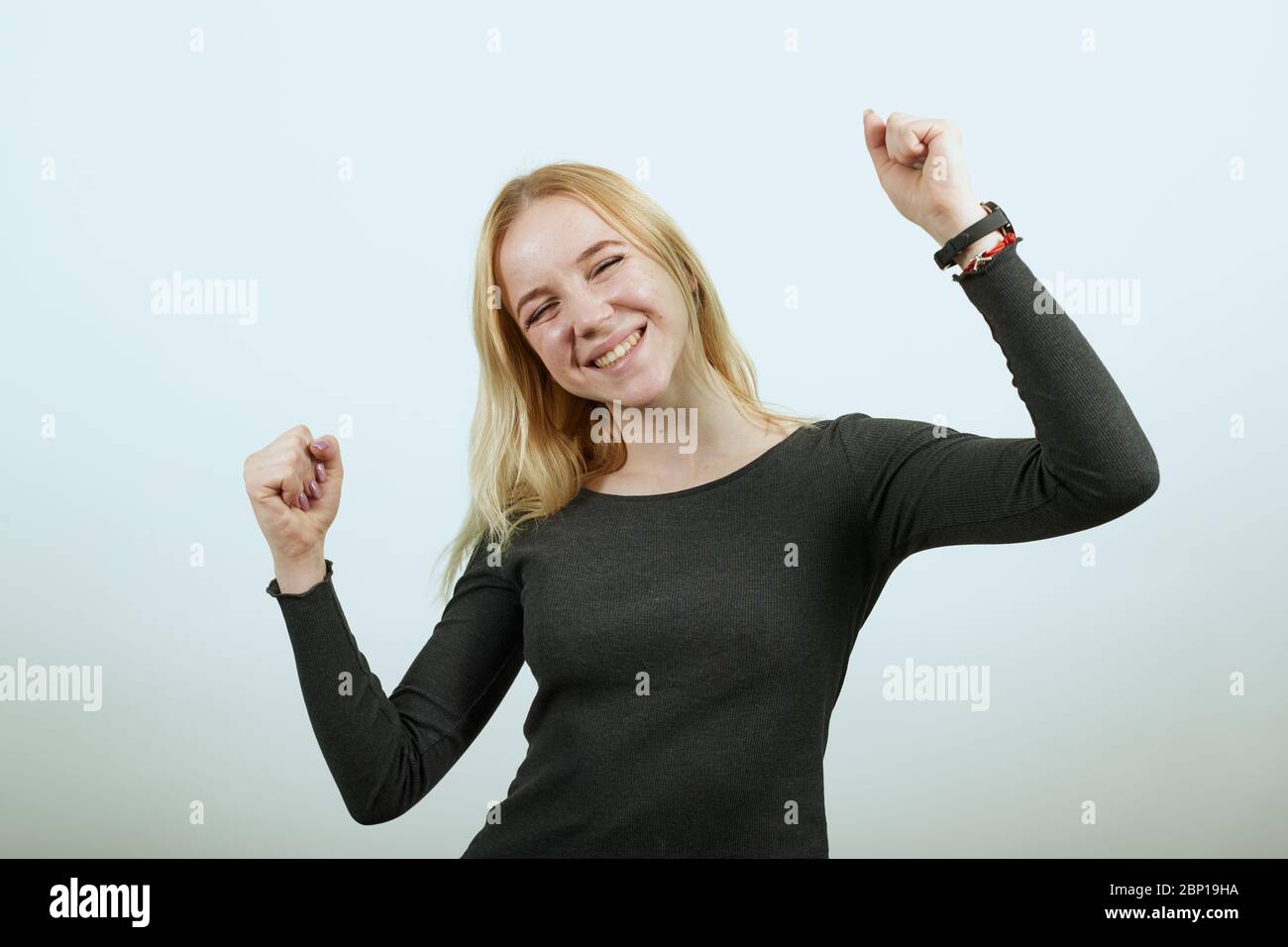 Happy Girl Smiles Clenched Her Hands Into A Fist And Raised Them Up Stock Photo Alamy