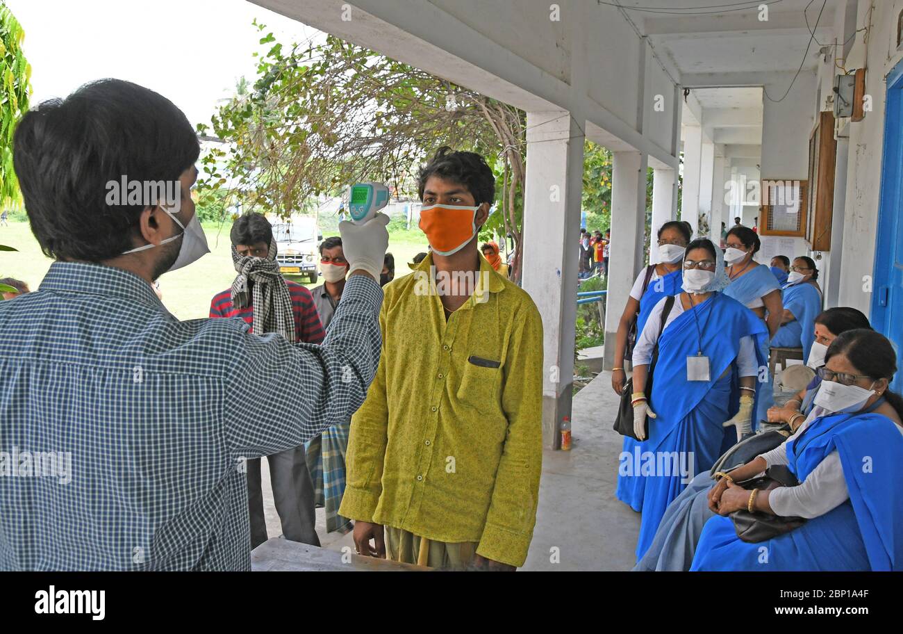 Migrant labourers rescued and confined at a 'Burdwan Bidyarthi Bhaban High School' complex have queued up for health screening for COVID-19) testing Stock Photo