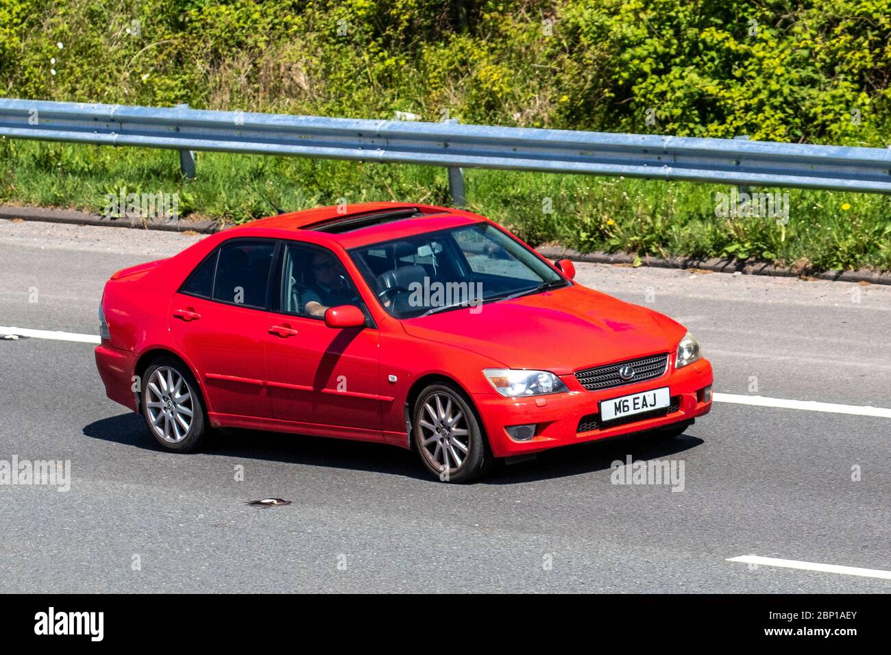 2005 red Lexus Is200 Sport; Vehicular traffic moving vehicles, driving vehicle on UK roads, motors, motoring on the M6 motorway highway Stock Photo