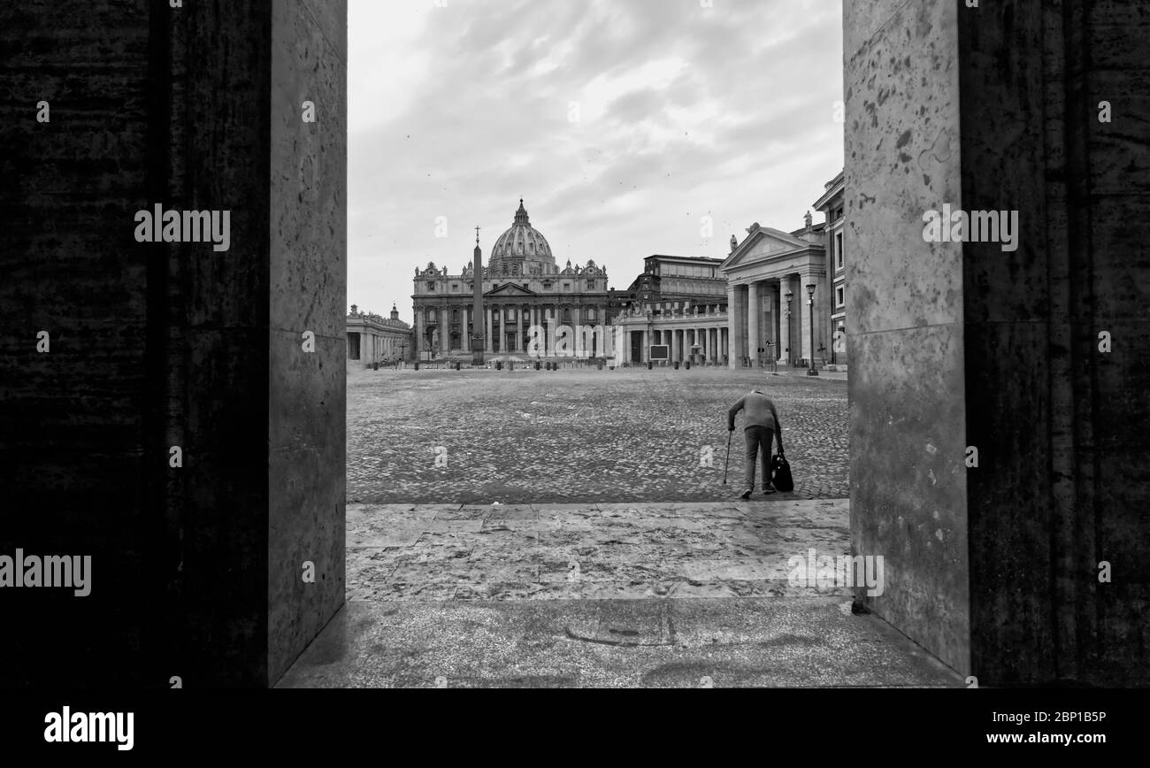 An old man walking with a stick in a desert St. Peter's Square Stock Photo