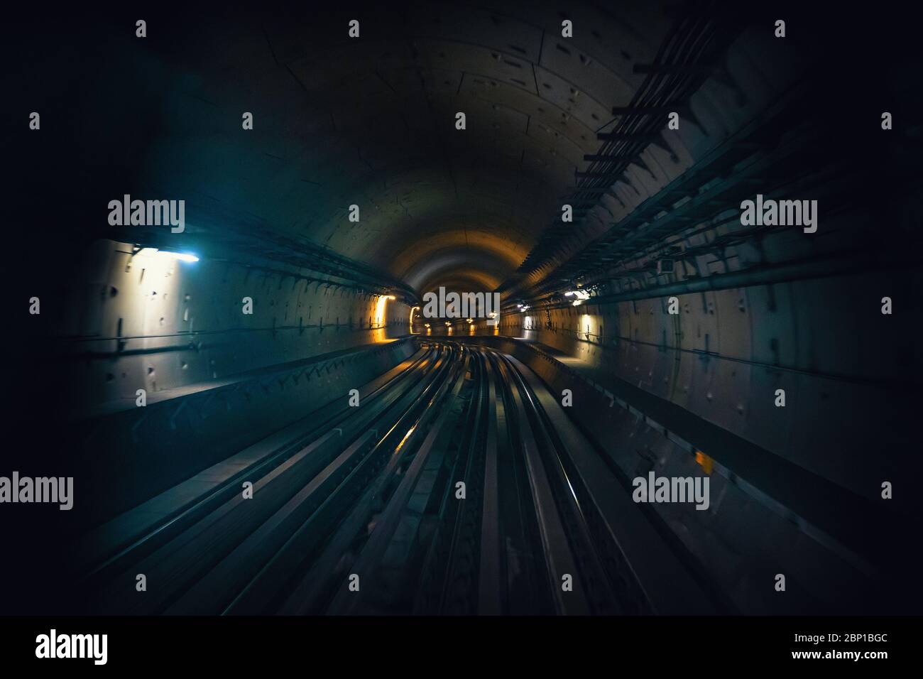 Dubai metro tunnel in blurred motion, view from first wagon, subway tracks. Stock Photo