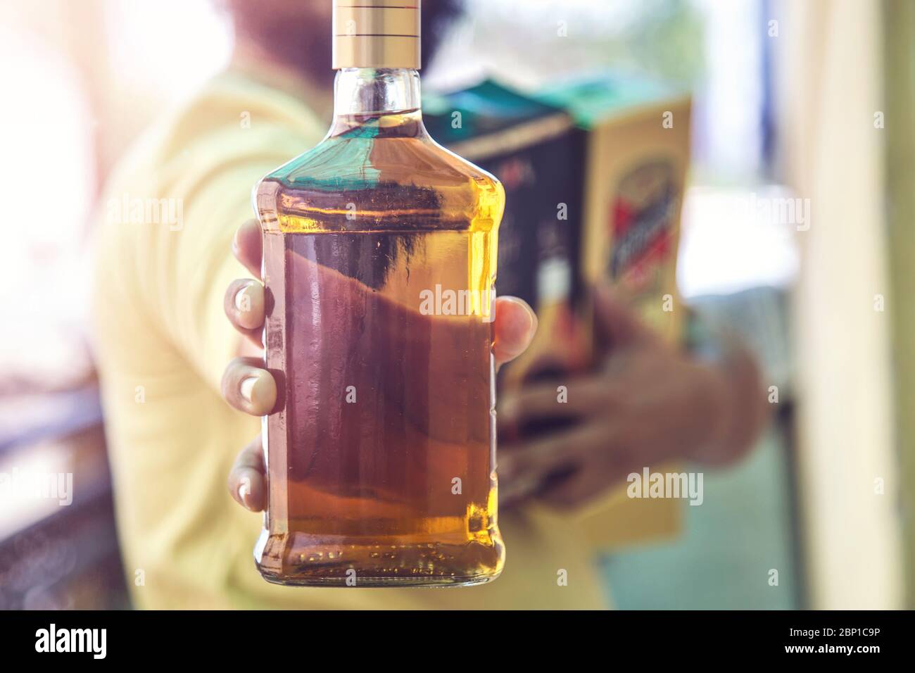 Close up of customer hand showing the whisky liquor bottle as he leave