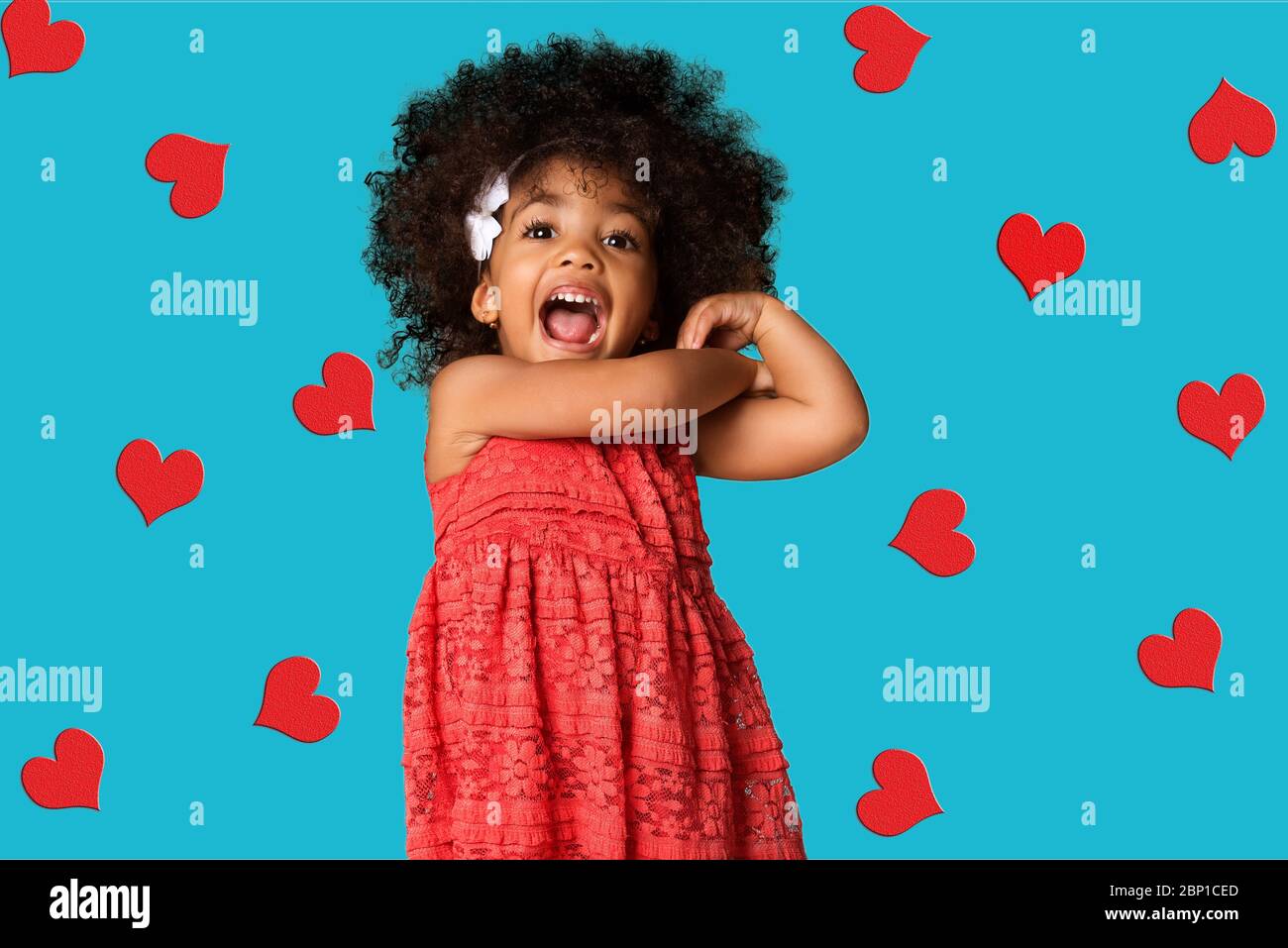 Portrait of cheerful happy african american little girl, over colored background with hearts Stock Photo