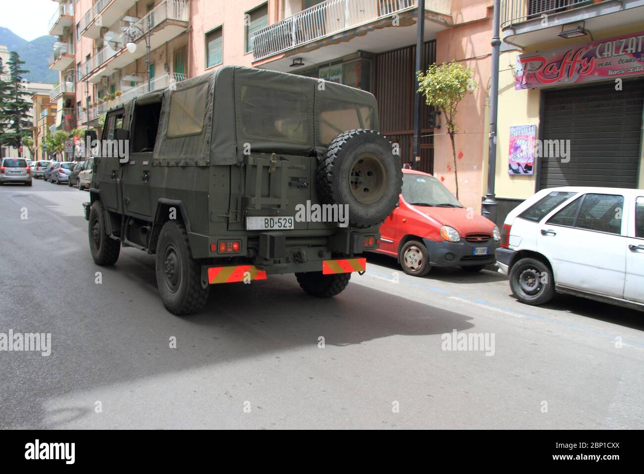 A military vehicle of the Italian army around the city center for an action to control compliance with the rules of social distance during phase 2 . Stock Photo