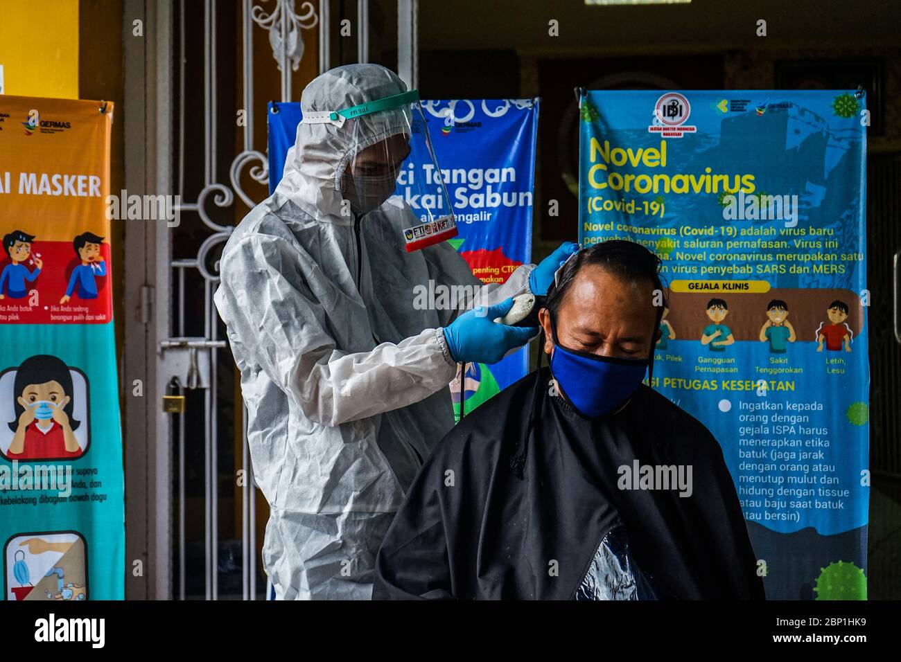 Makassar, Indonesia. 17th May, 2020. A barber cuts the hair of health  workers and doctors by using hazmat clothes and face shields according to  the Covid-19 protocol at the Indonesian Doctors Association
