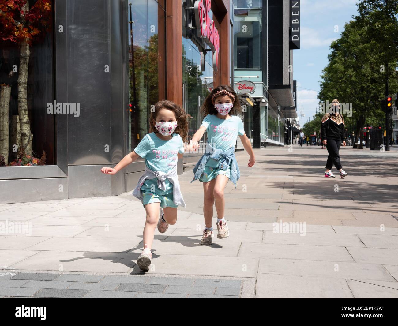 Two young girls playing in the street wearing face masks during the ...