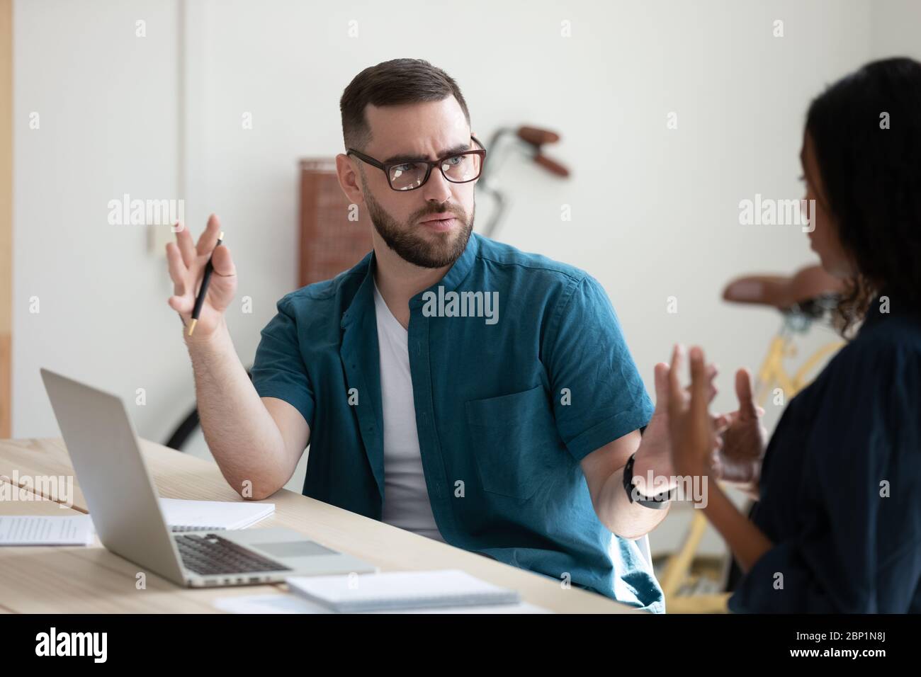 Serious businessman perplexed by female colleague decision in office. Stock Photo